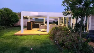 Illuminated White Louvered Pergola Evening Scene