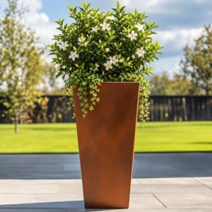 Corten steel tapered planter with flowering plants in an outdoor garden