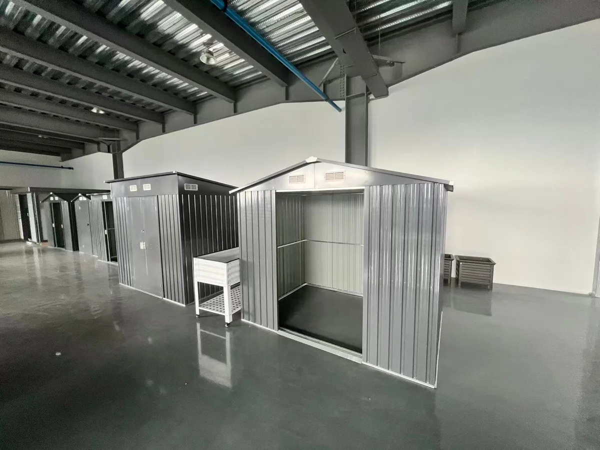 Assembled metal garden storage sheds with optional metal floor base kit displayed in YardAve factory showroom