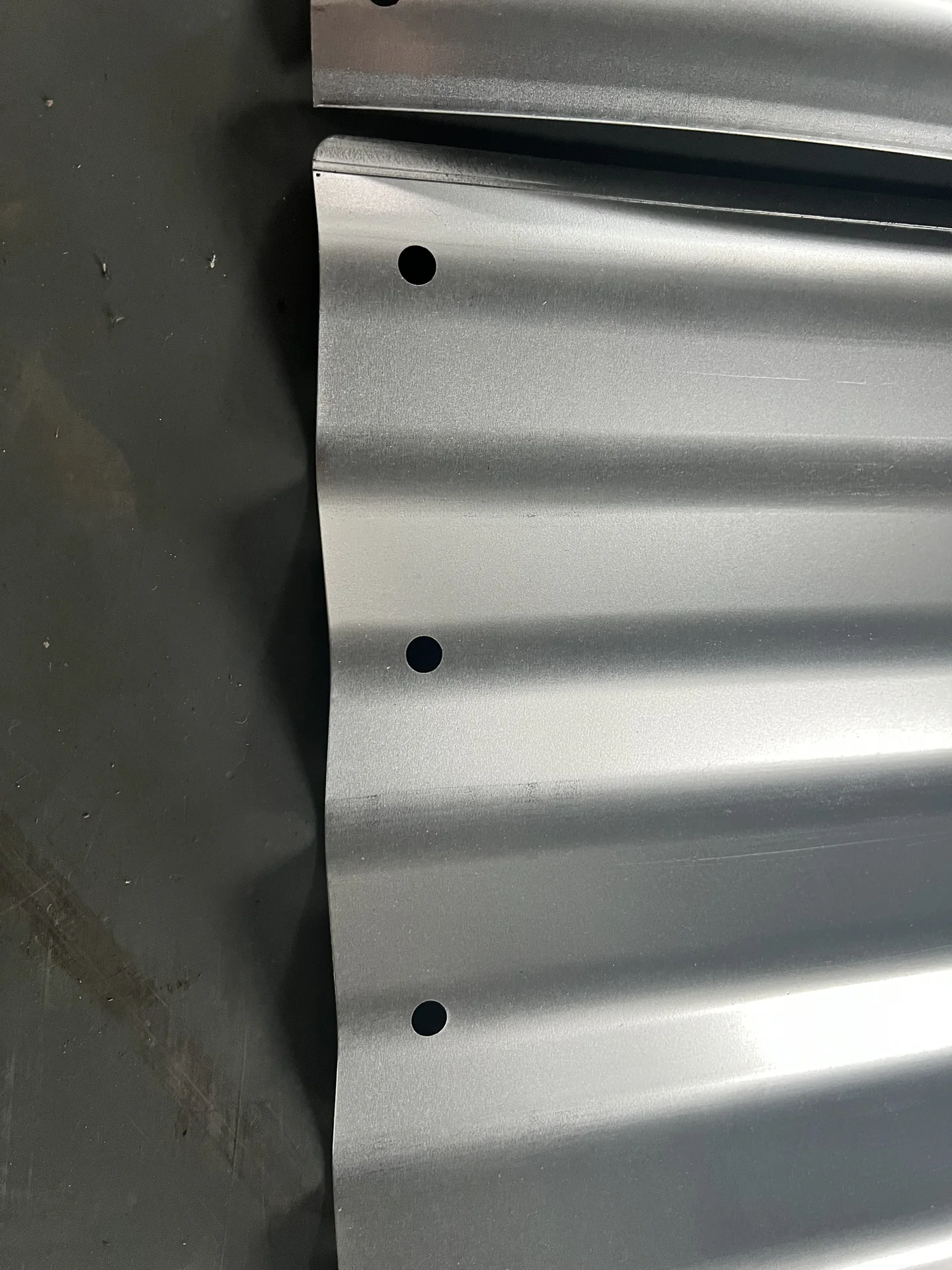 Rolled top edge and punched assembly holes on a corrugated raised bed panel
