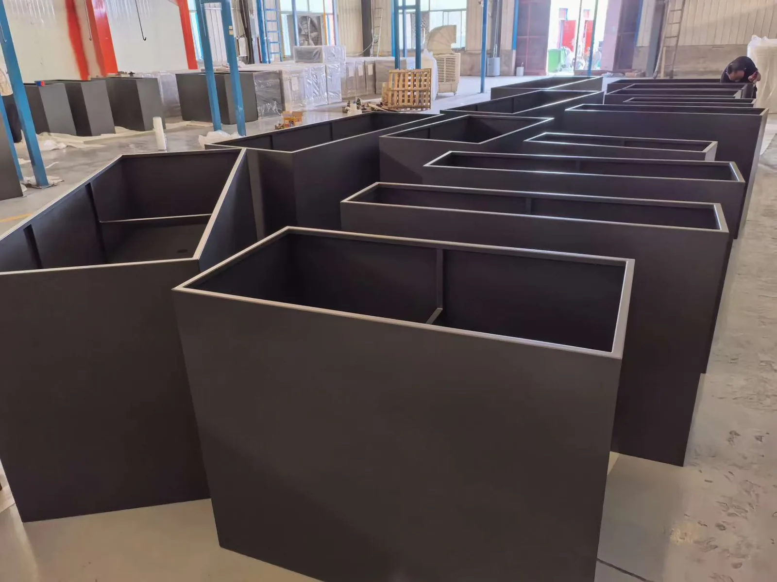 Custom metal planters organized inside a production workshop